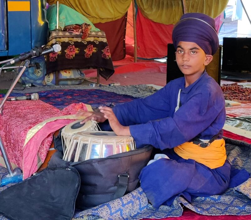 Fateh Singh, 14, playing tabla--a musical instrument at a makeshift Gurudwara or a Sikh temple at Singhu. Hundreds of thousands of farmers and Nihangs have set up tent cities on the highway connecting New Delhi. Taniya Dutta for The National