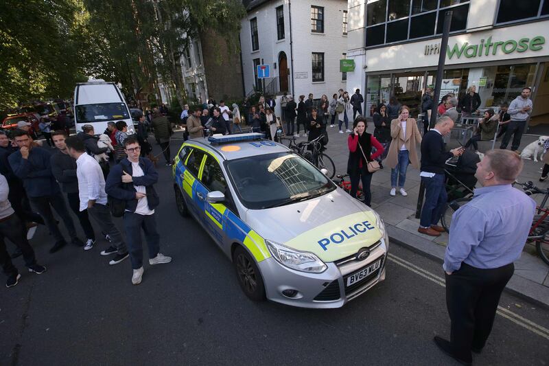 Londoners stand in a street close to the Parsons Green underground tube station. Daniel Leal-Oliva / AFP Photo