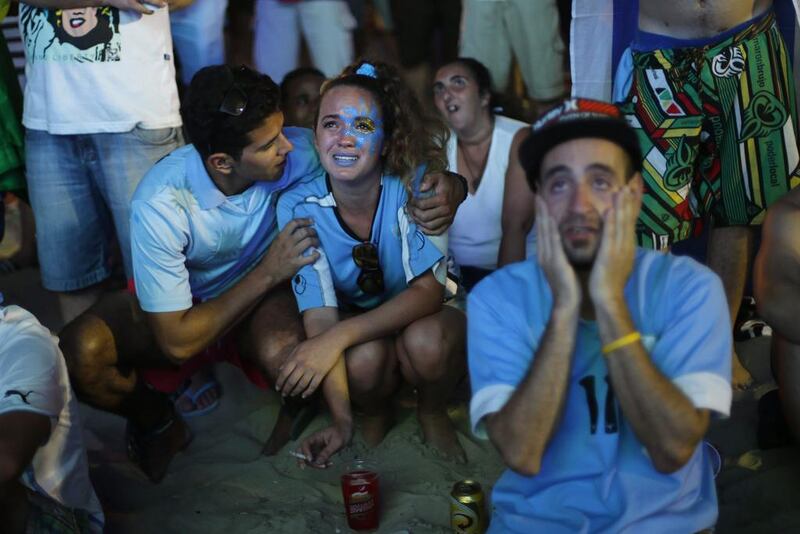An Uruguay football fan cries after her team’s defeat to Costa Rica. Silvia Izquierdo / AP Photo