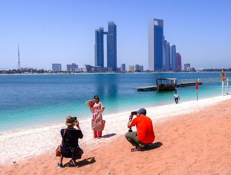 Tourists enjoy view of the Abu Dhabi skyline from Heritage Village. Photo: Victor Besa / The National