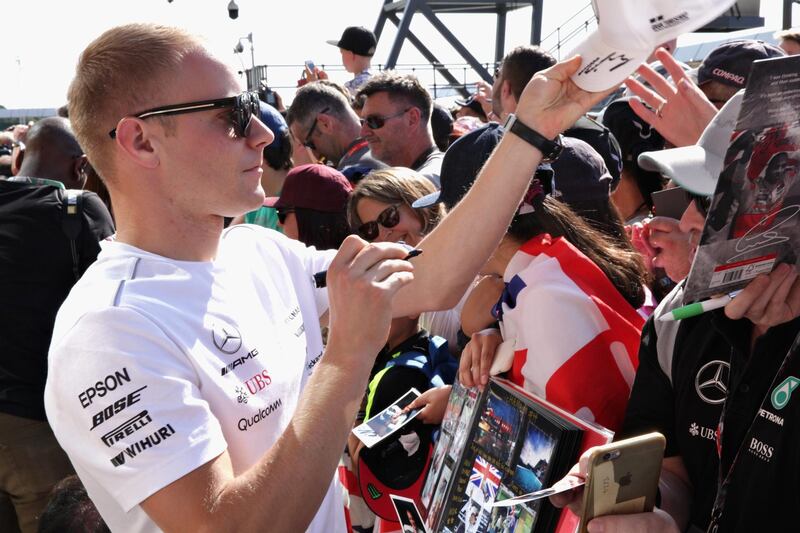 NORTHAMPTON, ENGLAND - JULY 05:  Valtteri Bottas of Finland and Mercedes GP signs autographs for fans during previews ahead of the Formula One Grand Prix of Great Britain at Silverstone on July 5, 2018 in Northampton, England.  (Photo by Russell Valentine/Getty Images)