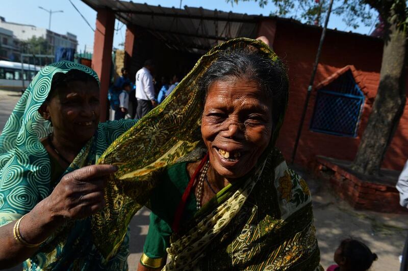 Malsamma, 62, another cured patient, gestures as she shares a light moment with her neighbour.