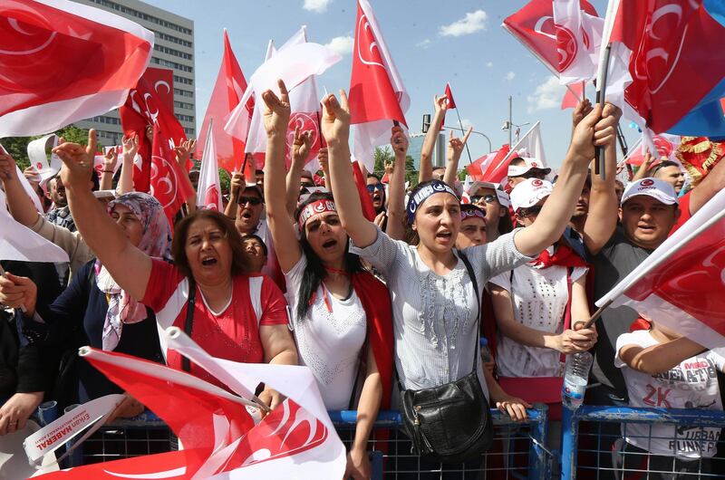 People gestures the "Grey Wolves" salutation and wave flafs during an election rally of Turkey's opposition Nationalist Action Party (MHP) May 24, 2015 in Ankara, ahead of the June 7 general elections. AFP PHOTO/ADEM ALTAN (Photo by ADEM ALTAN / AFP)