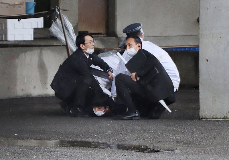 A man is arrested after throwing what appeared to be a smoke bomb in Wakayama on April 15. AFP