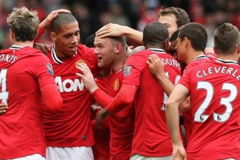 Wayne Rooney celebrates with his teammates after scoring his side’s third, and his second.
