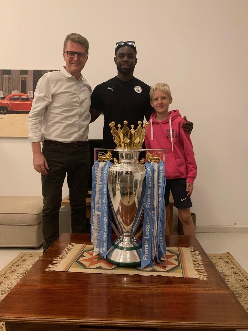 Nick March, Assistant Editor-in-Chief at The National, with his son Robert, right, and Micah Richards, during a home visit in Abu Dhabi with the Premier League trophy. Courtesy Nick March