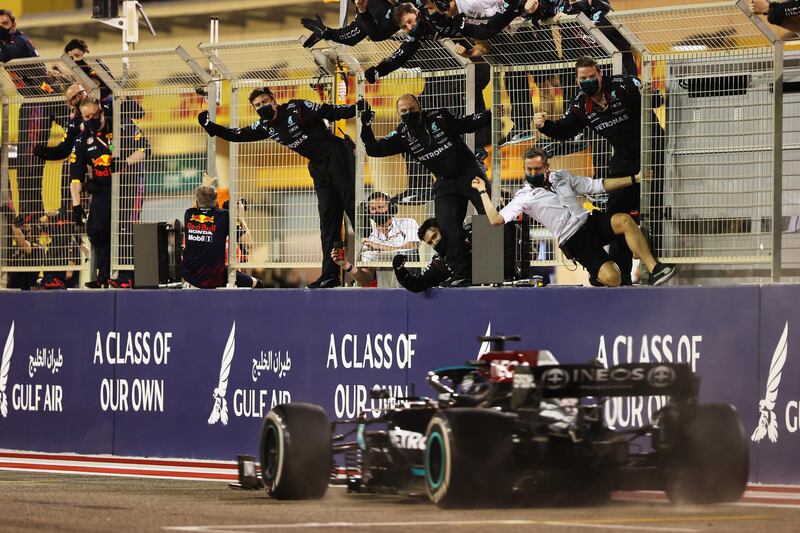 Mercedes team members celebrate on the pitwall as Lewis Hamilton crosses the finish line to win the Bahrain GP. Getty