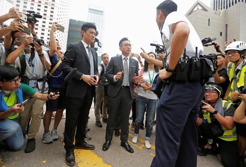 Lawmakers Jeremy Tam and Alvin Yeung of the Hong Kong Civic Party speak to a police officer. Reuters