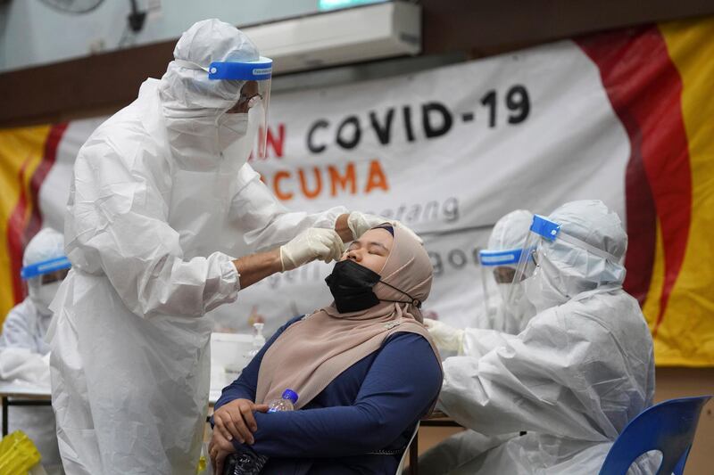 A medical worker collects a swab sample from a woman at a Covid-19 testing centre in Ulu Klang, on the outskirts of Kuala Lumpur, Malaysia. AP