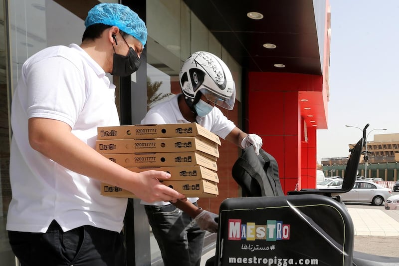 Delivery men wear protective face masks as they deliver food for customers in Riyadh, Saudi Arabia. Reuters