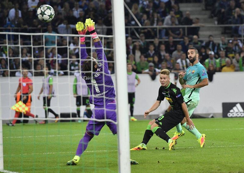 Barcelona’s Arda Turan, right, scores his side’s opening goal during the Champions League match against Borussia Monchengladbach. Martin Meissner / AP Photo