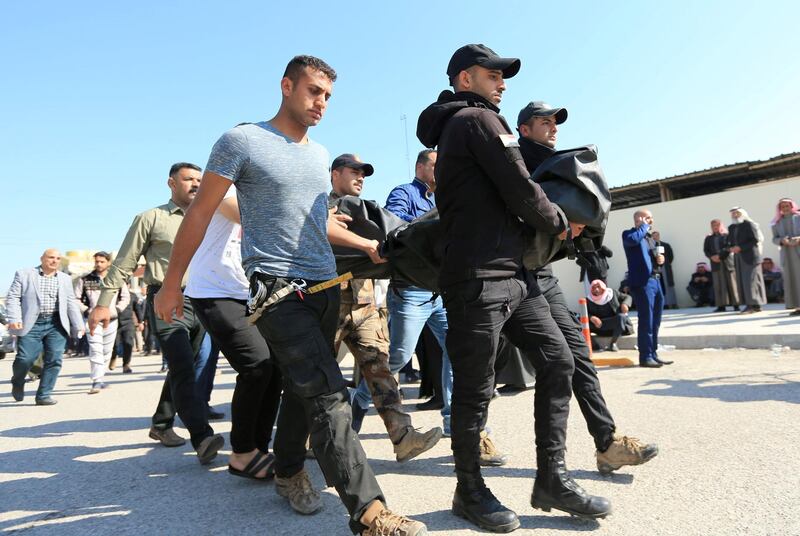 Men leave a morgue after collecting the body of their relative. Reuters