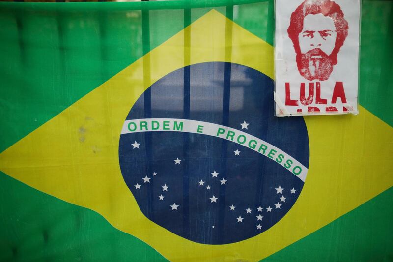 The image of Brazils jailed former president Luiz Inacio Lula da Silva with a Brazilian flag behind it hangs from a fence at Plaza de Mayo, during a protest against the visit of Brazil's President Jair Bolsonaro to Argentina, in Buenos Aires, Thursday, June 6, 2019.(AP Photo/Natacha Pisarenko)