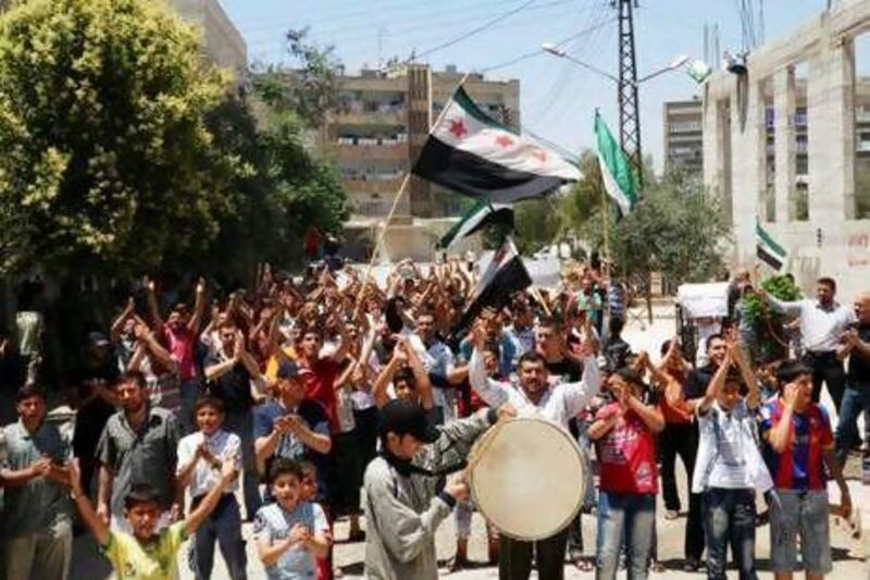 Anti-government protesters clap their hands as part of a funeral procession for Yaser Raqieh, whom protesters say was killed by forces loyal to Syria's President Bashar Al Assad, near Hama.