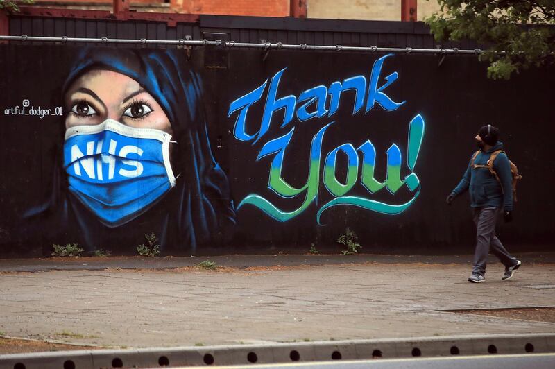 LONDON, ENGLAND  - APRIL 29: A man wearing a face mask walks past a piece of street art, created by The Artful Dodger, thanking the NHS on April 29, 2020 in London, England. British Prime Minister Boris Johnson, who returned to Downing Street this week after recovering from Covid-19, said the country needed to continue its lockdown measures to avoid a second spike in infections. (Photo by Andrew Redington/Getty Images)