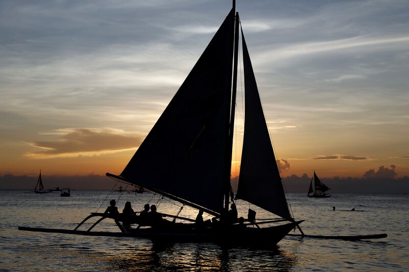 Tourists watch the sun set, on sailboats in Boracay. Reuters
