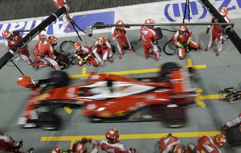 Ferrari driver Sebastian Vettel steers his car out of pit lane after a tire change during the Formula One Singapore Grand Prix. Wong May-E / AP Photo
