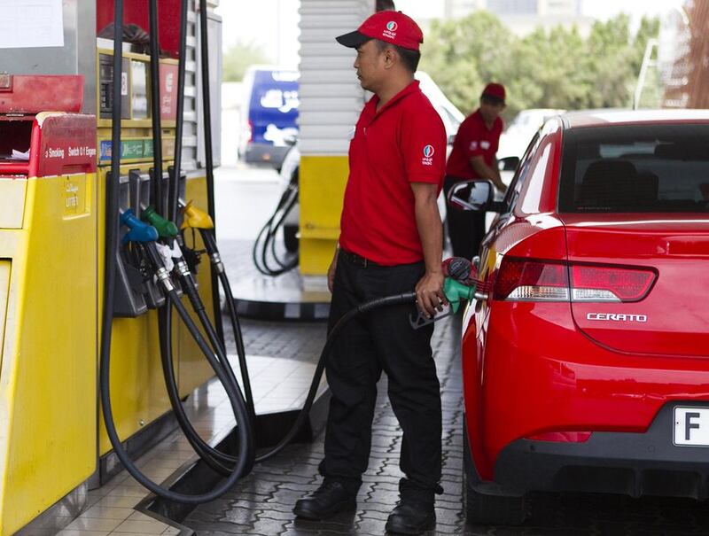 An Eppco worker pumps petrol at a service station, but the fall in global oil prices has not trickled down to the UAE. Sarah Dea / The National