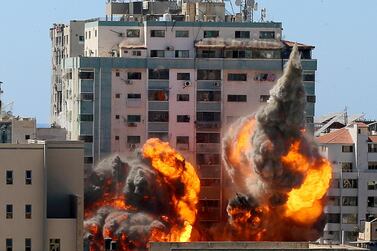 FILE PHOTO: An explosion is seen near a tower housing AP, Al Jazeera offices during Israeli missile strikes in Gaza city, May 15. REUTERS/Ashraf Abu Amrah/File Photo