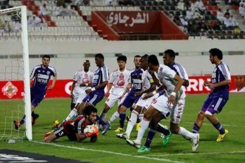 Al Ain's goalkeeper Dawoud Sulaiman stops an attempt by Sharjah.