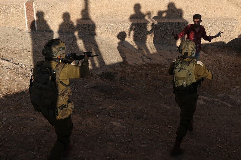 Israeli soldiers approach a Palestinian man during a search operation in Baita village in the occupied West Bank. AFP