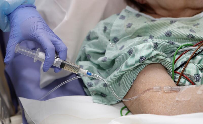 In this Monday, Jan. 8, 2018, photo, a nurse administers an I.V. push of antibiotics to patient Alice McDonald at ProMedica Toledo Hospital in Toledo, Ohio. A nasty flu season is hitting U.S. hospitals already scrambling to maintain patient care amid severe shortages of crucial sterile fluids, particularly saline solution needed to administer I.V. medicines and rehydrate patients. (AP Photo/Tony Dejak)