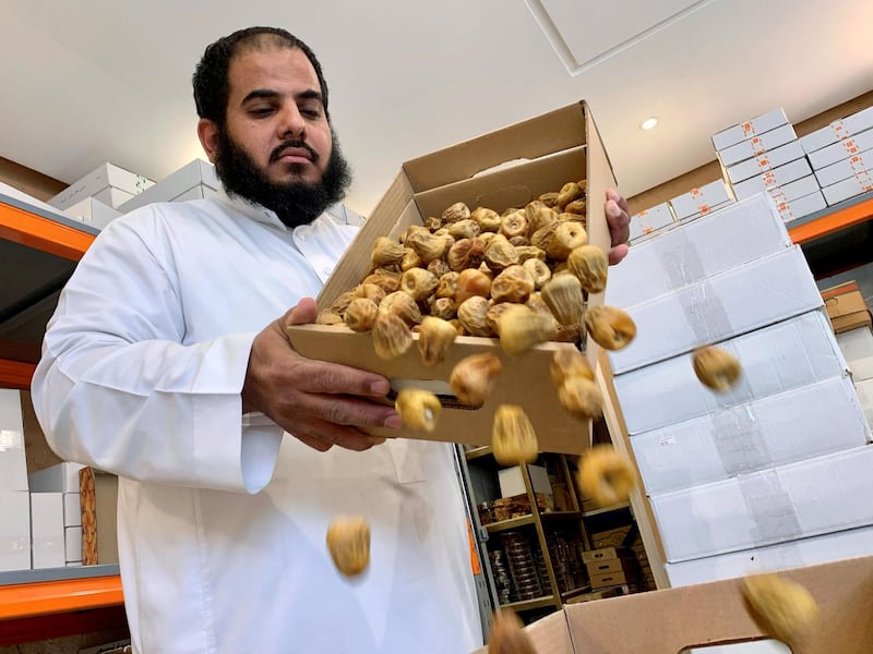 A Saudi seller pours dates into a box at his shop in Riyadh, Saudi Arabia. Reuters