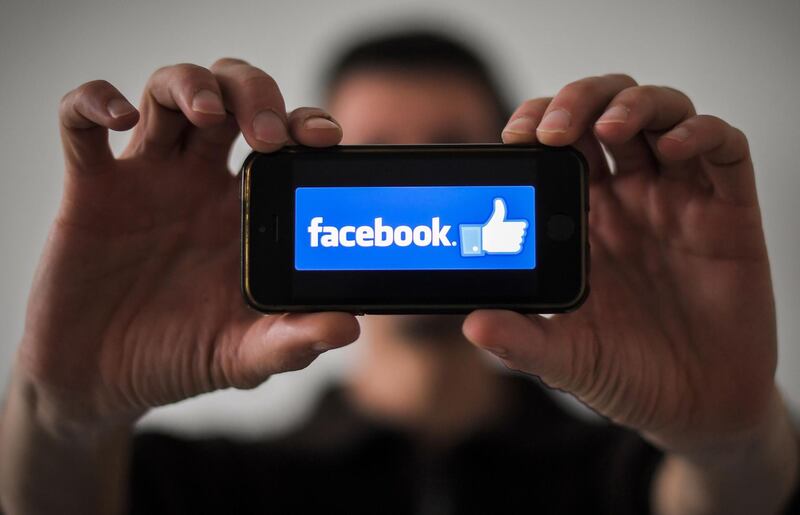 (FILES) In this file photo taken on January 15, 2019, a man shows the logo of social network Facebook displayed on a smartphone in Nantes, western France. Caryn Marooney, head of Facebook's public relations team, announced on February 6, 2019, she is leaving her job, stepping away after the most tumultuous period in the history of the social networking giant. / AFP / LOIC VENANCE
