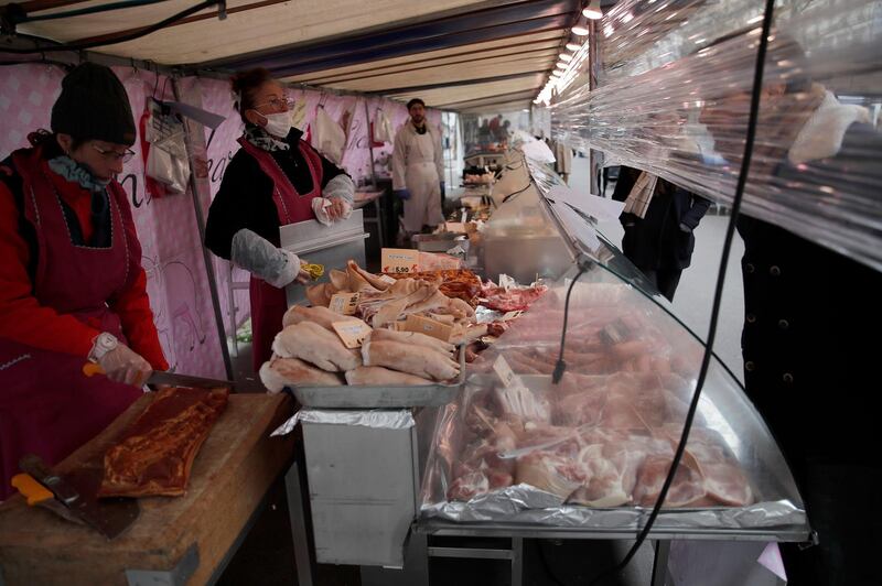 Vendors have installed plastic protection separating themselves from their customers in a street market in Paris, on March 21, 2020. AP Photo