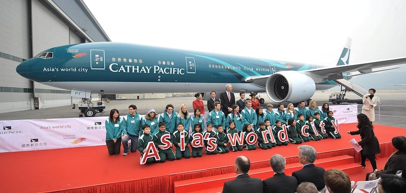 Representatives of Cathay Pacific pose with a Boeing 777-300ER aircraft in Hong Kong, 01 February 2008. Cathay Pacific have just taken delivery of a Boeing 777-300ER aircraft, the sixth of 30 aircraft to be delivered by 2012.       AFP PHOTO/MIKE CLARKE (Photo by MIKE CLARKE / AFP)
