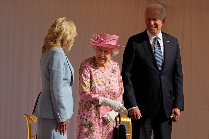 Queen Elizabeth II speaks to US First Lady Jill Biden while US President Joe Biden looks on as they watch a Guard of Honour march past before their meeting at Windsor Castle. Getty Images