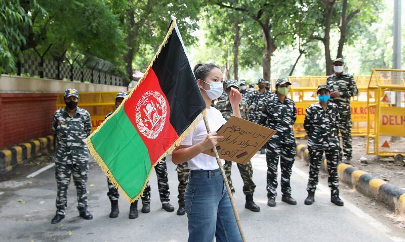 An Afghan refugee holds her country’s flag during a protest in New Delhi on Monday. Photo: EPA