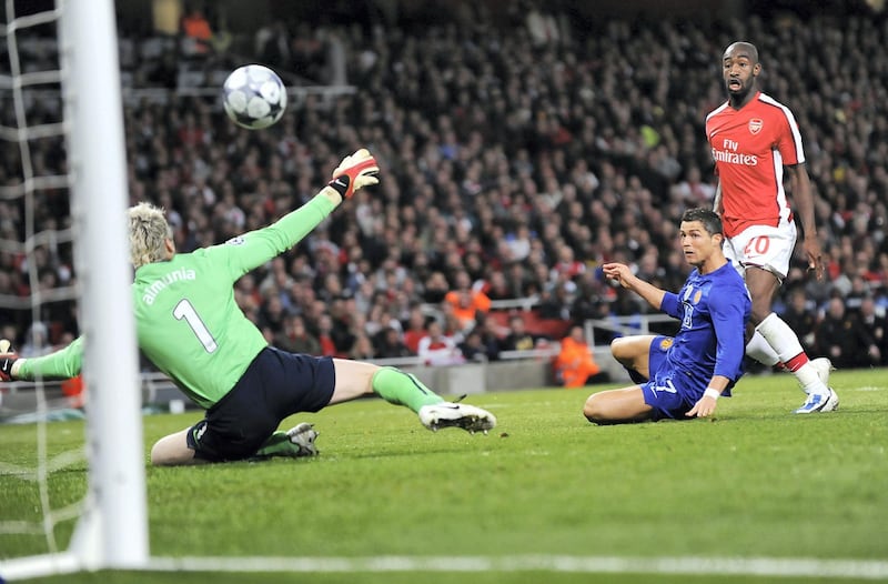 Manchester United's Portuguese midfielder Cristiano Ronaldo (C) scores his second goal past Arsenal's Spanish goalkeeper Manuel Almunia (L) during their UEFA Champions League semi final second leg football match against Arsenal at the Emirates Stadium, North London, England, on May 5, 2009. AFP PHOTO/CARL DE SOUZA / AFP PHOTO / CARL DE SOUZA