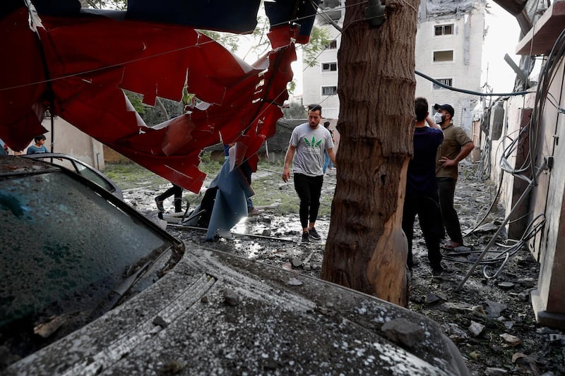 People inspect a destroyed car inside a house, following an Israeli airstrike on the upper floors of a commercial building in Gaza city. AP Photo