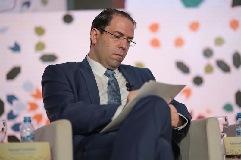 Tunisian Prime Minister Youssef Chahed takes notes during the opening session of the Opportunities For All economic conference in Marrakech, Morocco, Tuesday, Jan. 30, 2018. The conference supported by the IMF and the Arab Monetary Fund gathered over three hundred leaders from state and private sectors across the region to address the economic challenges it faces. (AP Photo/Mosa'ab Elshamy)