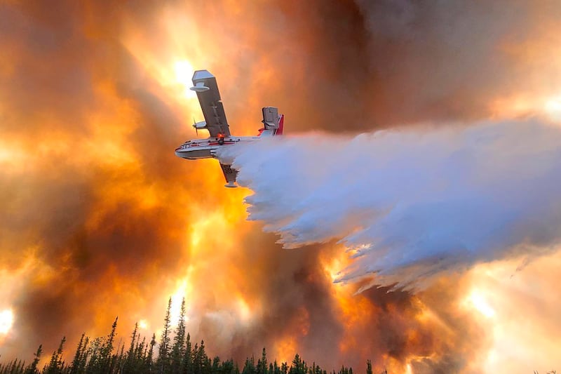 An Alaskan airplane drops water on the Clear Fire near Anderson, Alaska, on July 6. AP