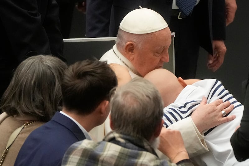 Pope Francis is hugged by a child as he meets staff at the Vatican Bambino Gesu Children's Hospital in Rome. AP