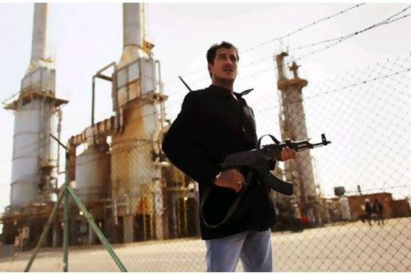 A rebel militiaman stands guard at a oil refinery yesterday in Al Brega, Libya.