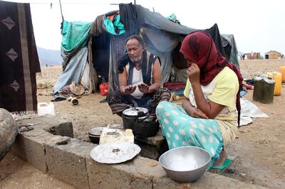 A Yemeni man warms his hands with cooking fire at a make-shift camp for displaced people who fled fighting between the Huthi rebels and the Saudi-backed government, in the Abs district of the northwestern Hajjah province on January 23, 2020.  Yemen's internationally recognised government, backed by a Saudi-led military coalition, has been battling the Iran-allied rebels since 2014, when they overran the capital Sanaa. / AFP / ESSA AHMED
