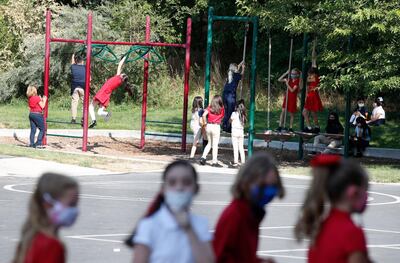 Students wearing protective masks play outside during recess at a public charter school in Provo, Utah, U.S., on Thursday, Aug. 20, 2020. Students and staff in Utah who don’t wear a mask in K-12 schools in accordance with the  Governor Gary Herbert’s mandate can be charged with a misdemeanor, reported the Salt Lake Tribune. George Frey/Bloomberg