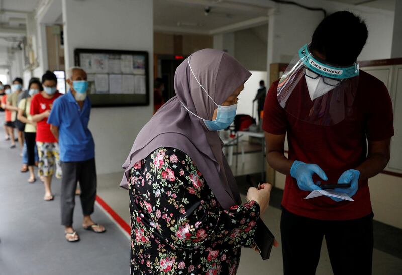 Residents of a public housing estate queue up for their mandatory coronavirus disease (COVID-19) swab tests after some residents were tested positive for the virus, in Singapore May 21, 2021.   REUTERS/Edgar Su