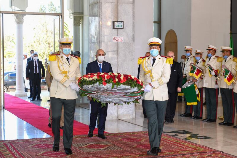 Algeria's President Abdelmajid Tebboune prays during a ceremony to lay to rest the remains of 24 resistance fighters, returned from Paris. AFP