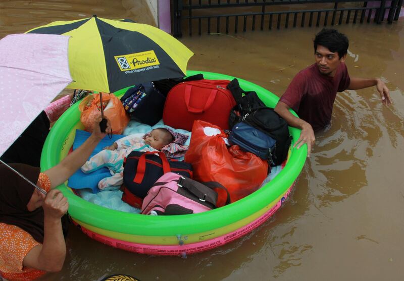 A baby is evacuated by a rescue team using an inflatable boat after floods hit a residential area in Tangerang, near Jakarta, Indonesia.  Reuters