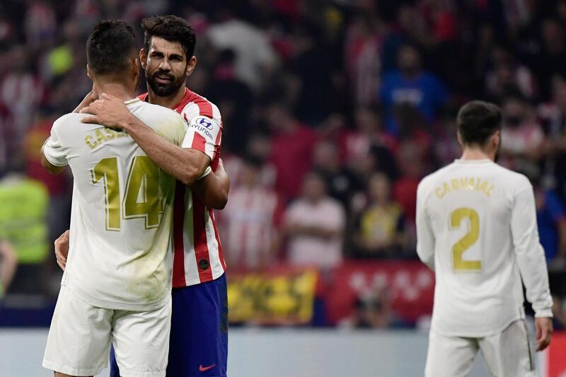 Atletico Madrid's Spanish forward Diego Costa (R) hugs Real Madrid's Brazilian midfielder Casemiro at the end of the Spanish league football match between Club Atletico de Madrid and Real Madrid CF at the Wanda Metropolitano stadium in Madrid on September 28, 2019. / AFP / JAVIER SORIANO
