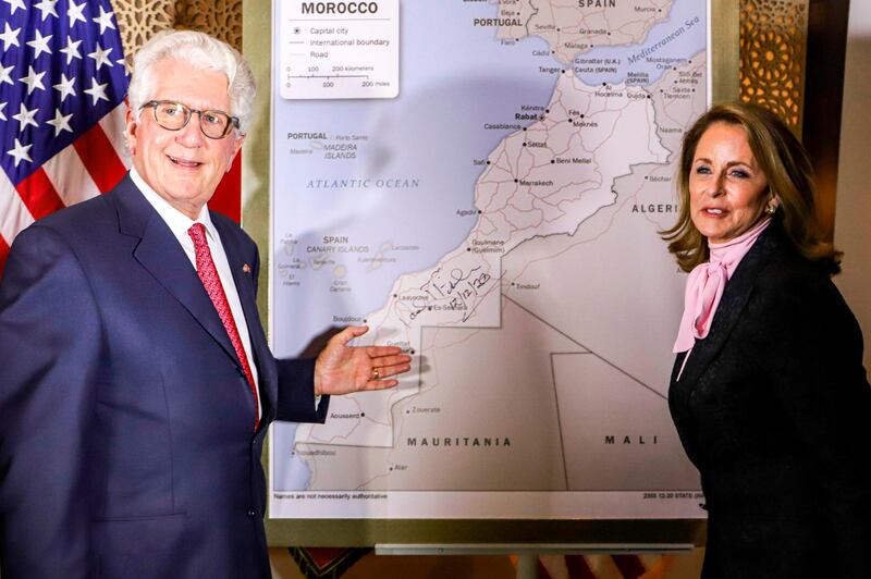 David T. Fischer (L), US Ambassador to the Kingdom of Morocco, and his wife Jennifer (R) stand before a US State Department-authorised map of Morocco recognising the internationally-disputed territory of the Western Sahara (bearing a signature by Fischer) as a part of the North African kingdom, in Morocco's capital Rabat on December 12, 2020. / AFP / -
