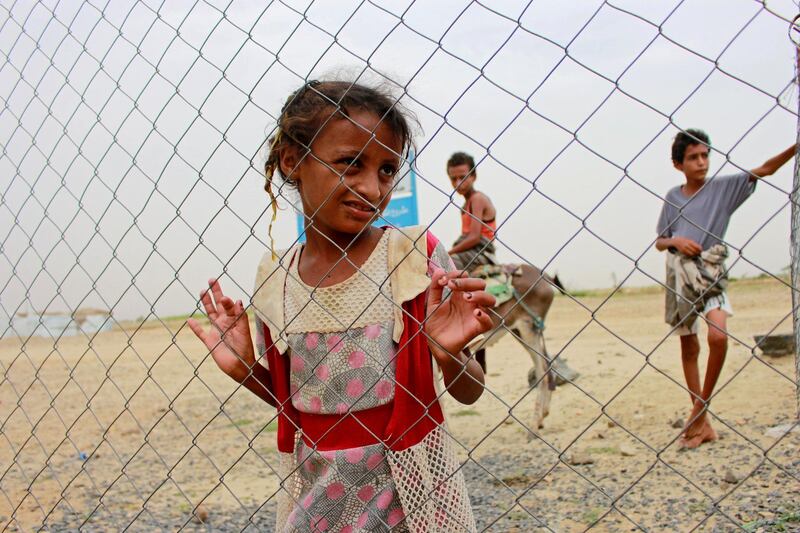 A girl looks through the fence of a closed clinic at a camp for internally displaced people near Abs of Hajjah province, Yemen August 19, 2020. Picture taken August 19, 2020. REUTERS/Eissa Alragehi NO RESALES. NO ARCHIVES.