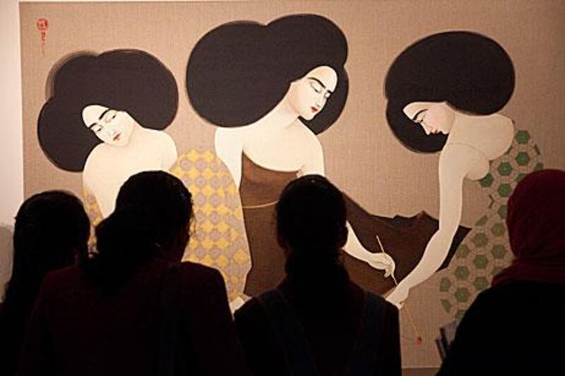 Visitors view The Triangle by Hayv Kahraman at Christie's auction house at the Emirates Tower Hotel in Dubai.