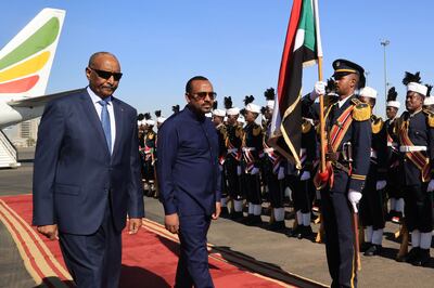 Abiy Ahmed, right, alongside Gen Abdel Fattah Al Burhan at Khartoum Airport during a welcome ceremony. AFP