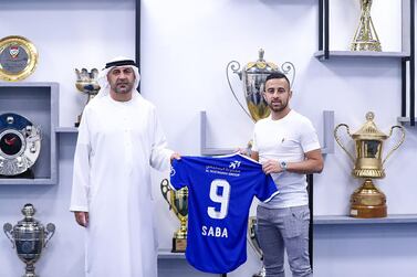 Israeli midfielder Diaa Saba poses with a club official after signing with UAE club Al Nasr. AFP