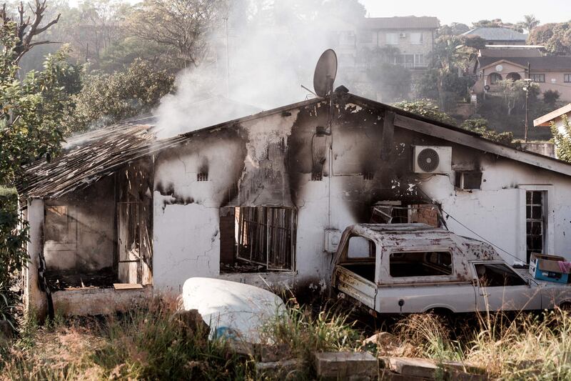 A picture taken on July 16, 2021 shows a house destroyed after angry mobs set fire to homes in Duffs Road near Phoenix, where racial tensions have also been reported as President Cyril Ramaphosa visits the Kwazulu-Natal province where violence continued for 6 days.  - South African President Cyril Ramaphosa on Friday alleged that deadly violence and looting that have shaken the country over the past week were planned. 
"It is quite clear that all these incidents of unrest and looting were instigated -- there were people who planned it and coordinated it," Ramaphosa said in a visit to KwaZulu-Natal (KZN) province, the flarepoint for post-apartheid South Africa's worst crisis.